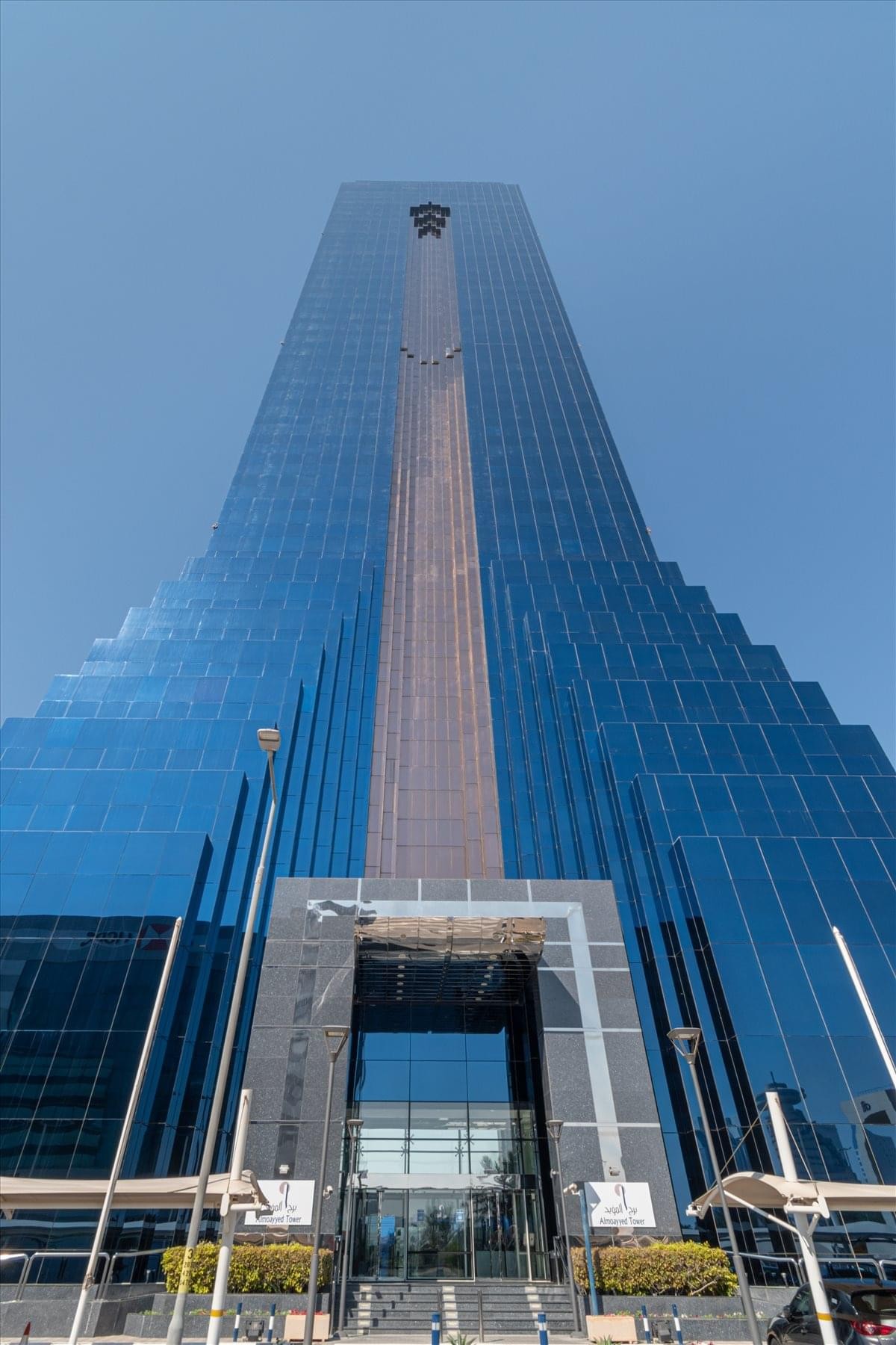 Exterior view of the Almoayyed Tower in Manama with glass facade.