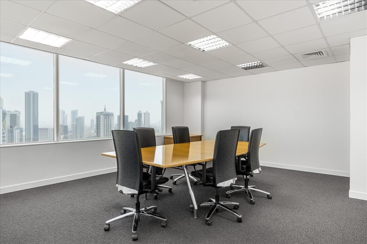 Spacious boardroom with a large wooden table and panoramic city views.
