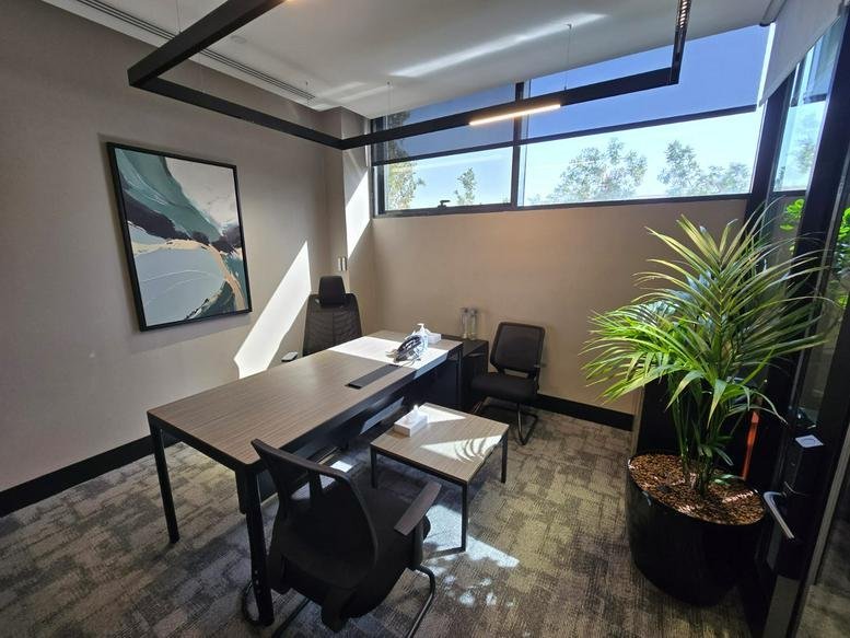 Private executive office at Althalia Rd, Almathar Alshimali with landscape wall art and desk.