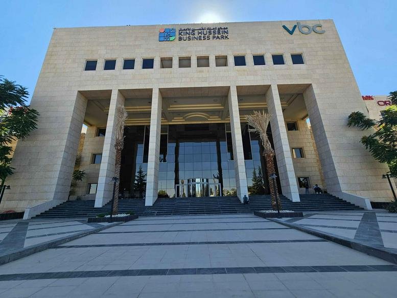 Exterior facade and grand entrance of the Amman King Hussein Business Park under a clear sky.