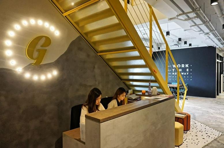 Reception area at Arion Commerical Centre with a lit G logo and yellow staircase.