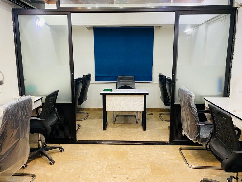 Internal office suite at Baradari Apartments, A-20, Karachi, Pakistan with a central desk and blue window blind.