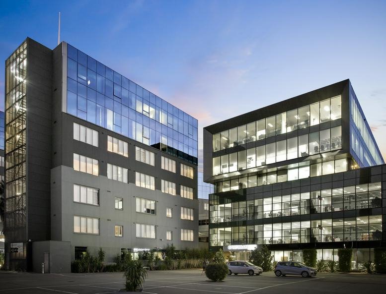 Exterior view of the modern glass-facade Bell City Serviced Offices building at dusk.