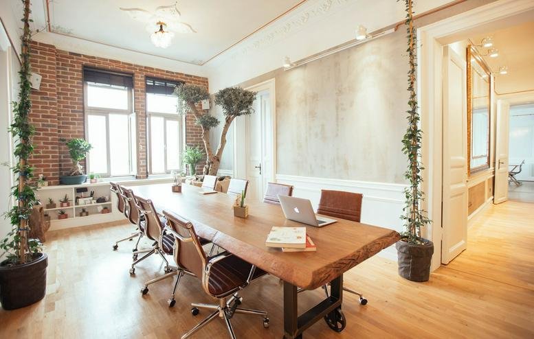 Meeting room at Beyoglu Nejat Eczacibasi Binasi with a live-edge wooden table and exposed brick walls.