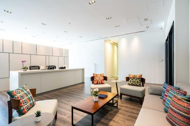 Bright reception desk at Billion Plaza II with modern wood flooring and colorful accent chairs.
