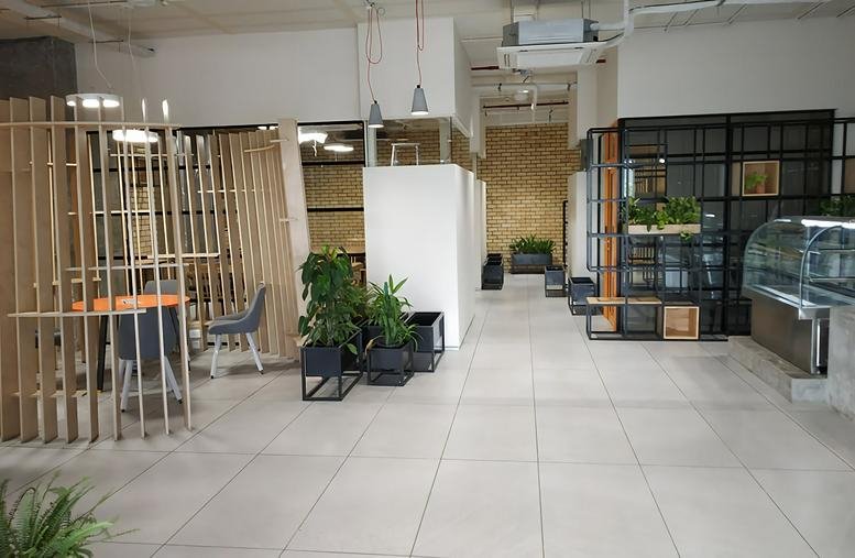 Spacious communal area at BKC, Trade Centre, BandraKurla Complex featuring wooden slats and indoor plants.