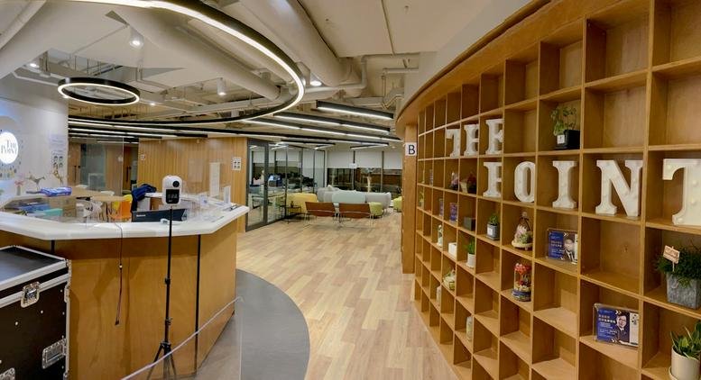 Spacious reception area with curved wooden bookshelves and warm lighting at New Mandarin Plaza.