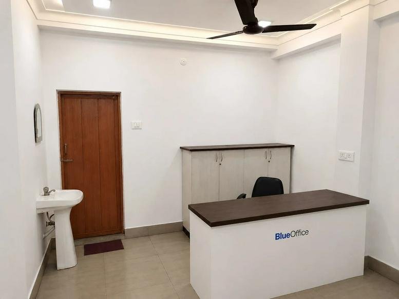 Reception area at BlueOffice Workspace, 301, AC-119/1, Kestopur, Kolkata, India with a white desk and wood door.