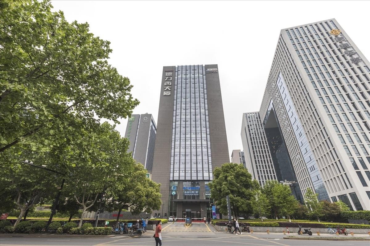 Exterior view of the modern high-rise Building A, Delixi Mansion on a tree-lined street.