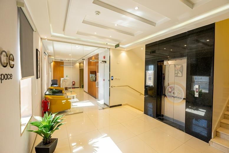 Spacious reception area of Building No. 6143 with polished floors and elegant black elevator doors.