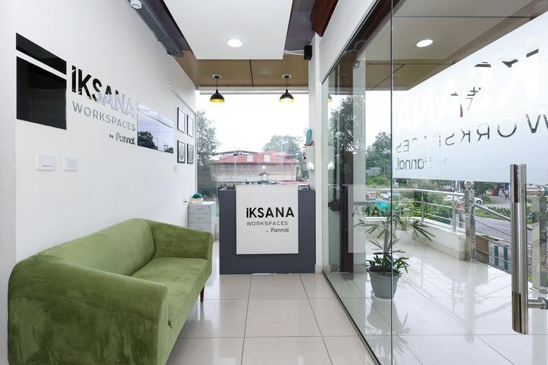 Bright reception area at Anand Arcade, Canal Road, IT Park, Dehradun, India with a green sofa and glass entrance.