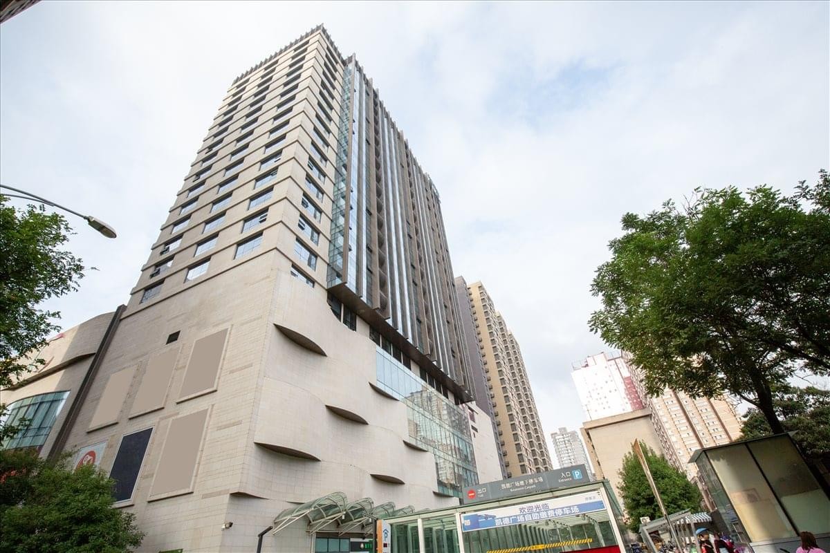 Exterior view of the CapitaMall Office building featuring a modern stone facade and tall tower.