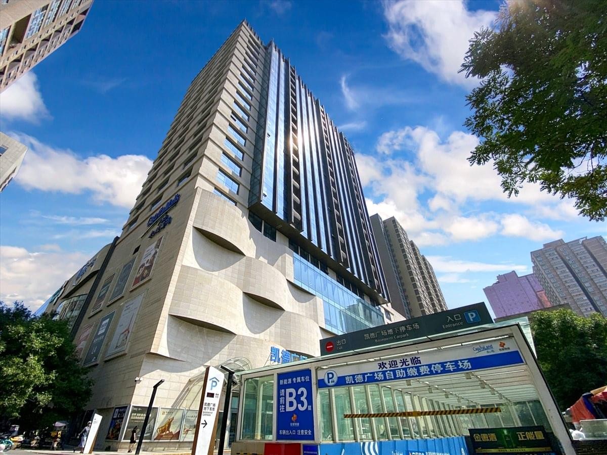 Wide-angle view of the tall modern commercial tower under a blue sky.