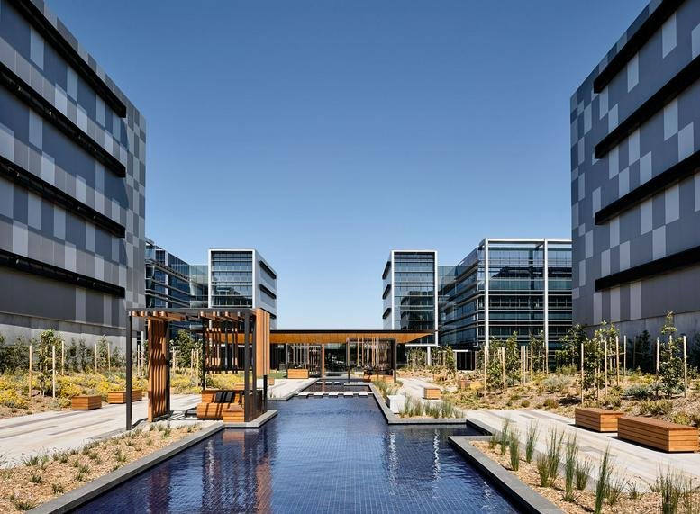 Exterior view of the modern glass-facade buildings and reflective pool at Caribbean Park, 44 Lakeview Drive.