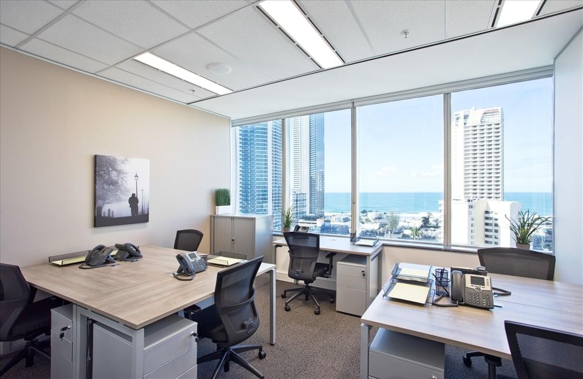 Spacious light-filled corner office with multiple workstations and panoramic ocean views.