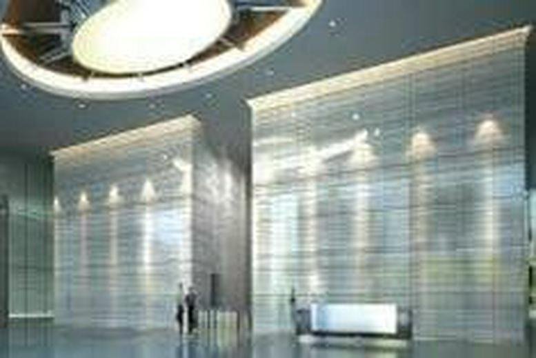 The grand, high-ceilinged lobby entrance with illuminated marble feature walls at Centennial Tower.