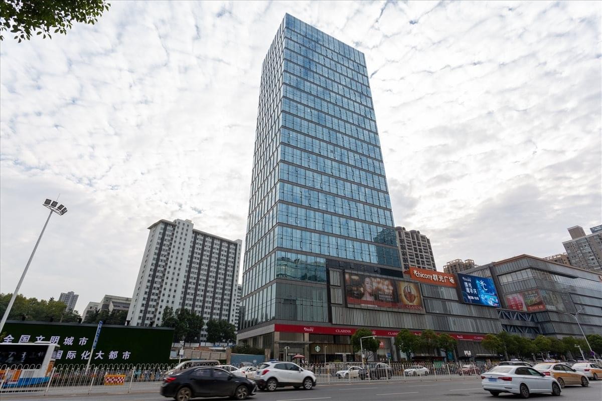 Exterior view of the glass-facade Chicony Centre skyscraper against a cloudy sky.