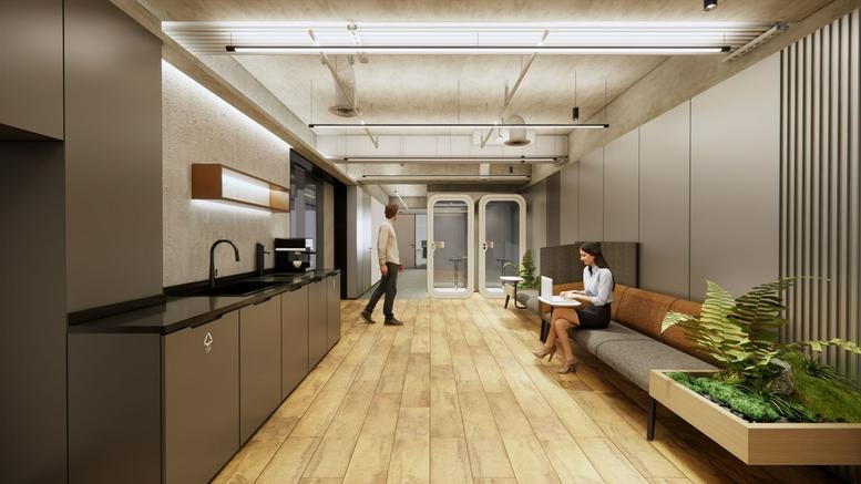 Modern communal kitchen and lounge area with light wood floors, potted plants, and sleek dark cabinetry.
