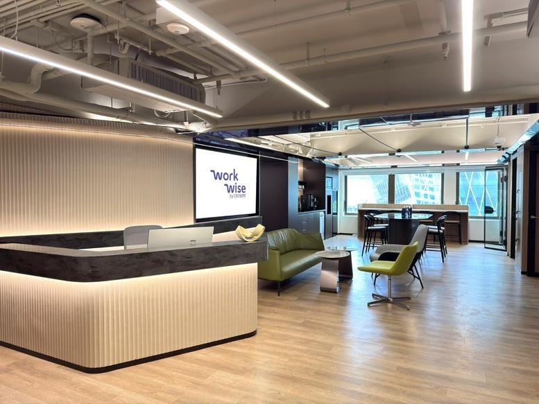 Lobby area featuring a curved wooden reception desk with warm under-lighting and a logo on the wall.