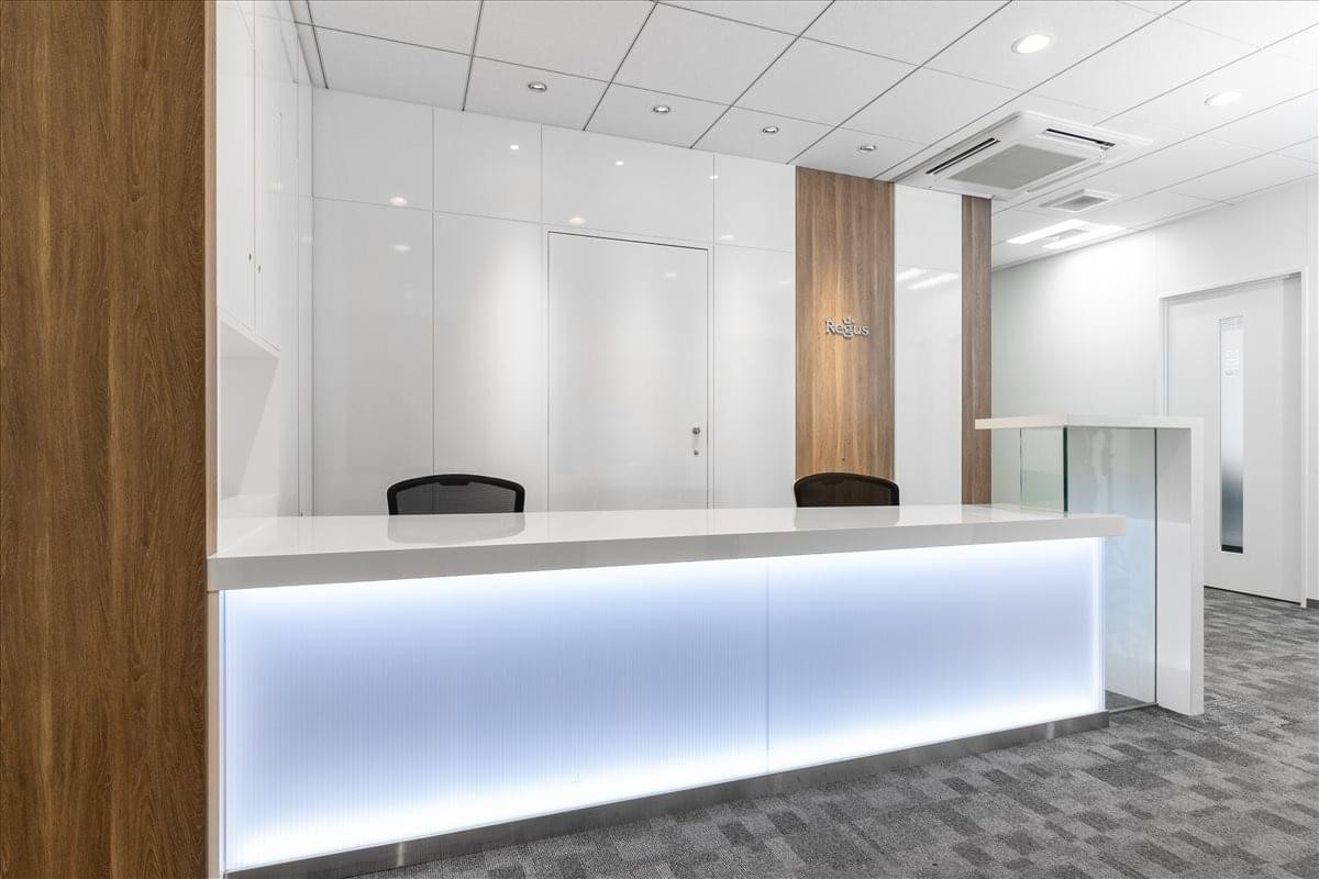 Bright reception desk with integrated LED lighting and wood-paneled accent walls.