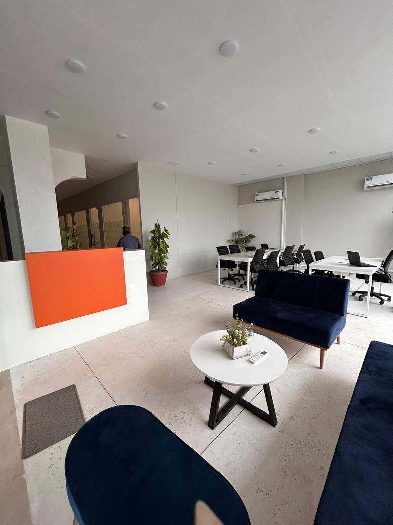 Well-lit reception lounge at Com3 Showroom No. 5 with blue sofas and a minimalist coffee table.