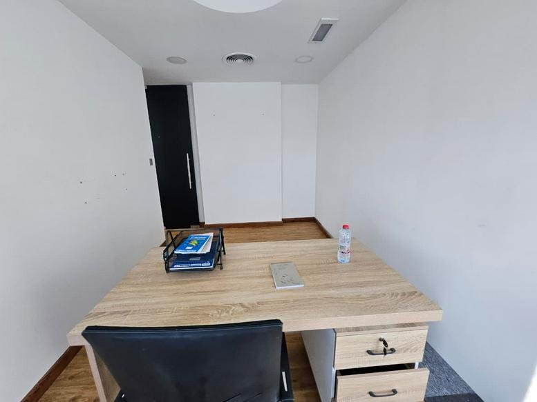 Minimalist private office at Concord Tower, Dubai Media City featuring a clean wooden desk.