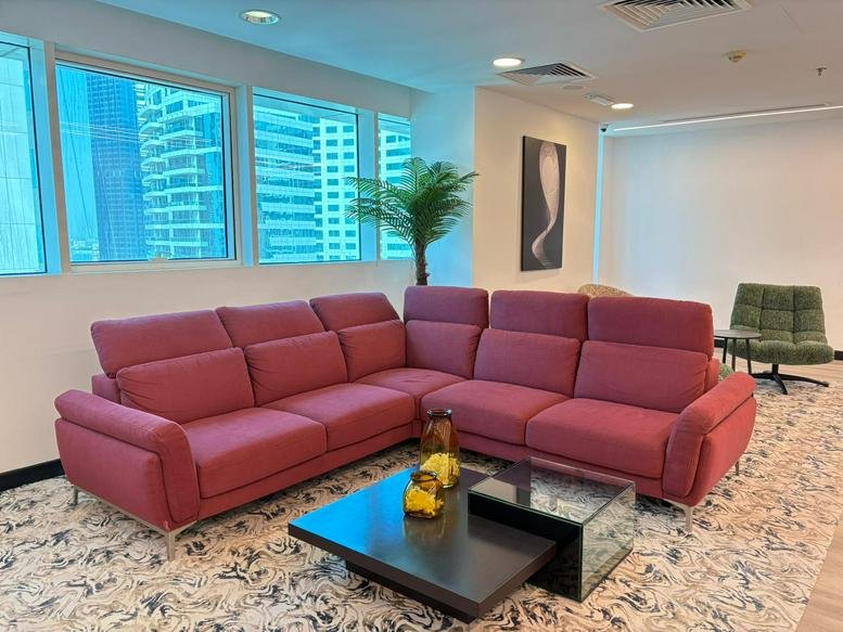 Communal lounge area at Conference Centre, West Bay, Doha, Qatar with a large plush red sectional sofa.