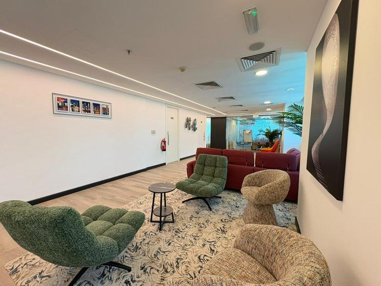 Conference Centre, West Bay, Doha, Qatar lounge featuring green armchairs and a red sofa on a patterned rug.