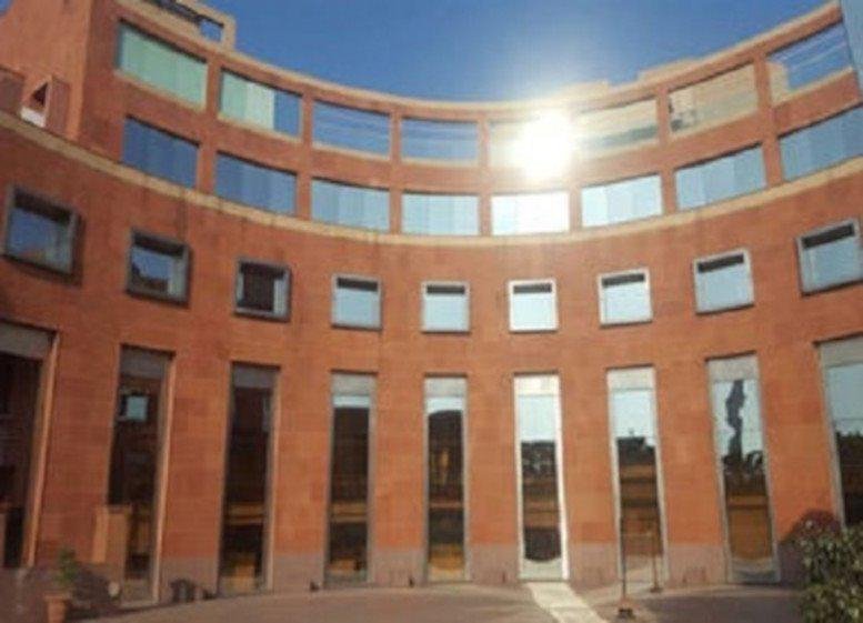 Curved brick facade and reflective windows of the Crescent Building, Lado Sarai Mehrauli.