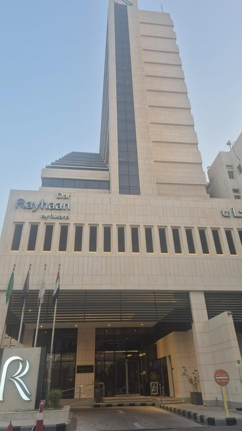 Exterior view of the tall, modern stone facade of the Dar Rayhaan by Rotana building.