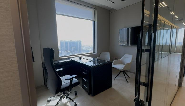 Wide-angle view of the modern interior at Dar Rayhan by Rotana featuring a private office and glass partitions.