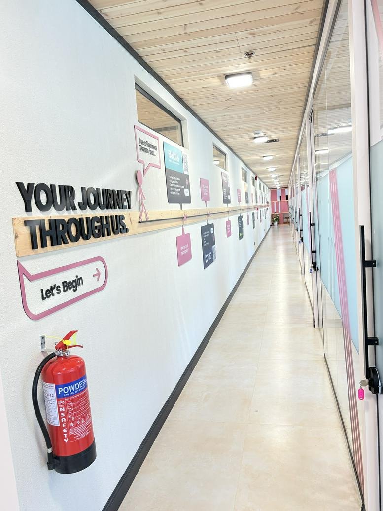 Bright corridor at Dar Rayhan by Rotana featuring a graphic wall timeline and a wooden ceiling.