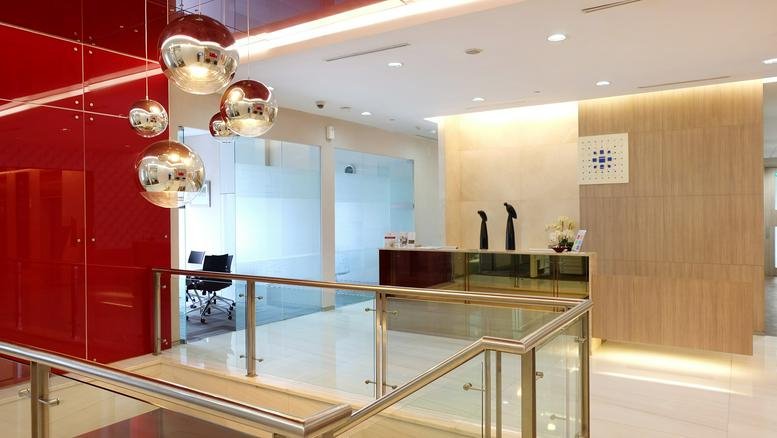 Elevated view of a modern reception area with red glass feature wall and pendant lighting.