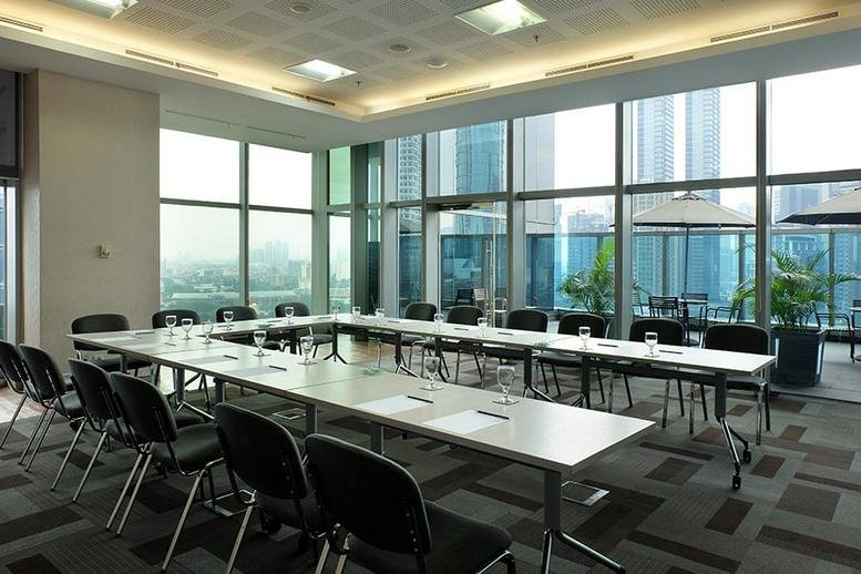 Spacious boardroom with U-shaped table setup and floor-to-ceiling windows.