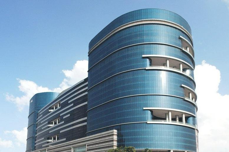 Exterior view of the curved glass facade of Building 5, Tower A at DLF Cyber City.