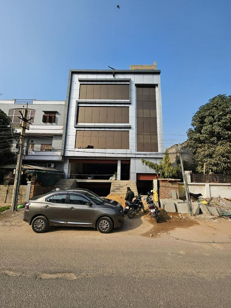 Exterior view of Arvian Workspaces, Akruti Apartments, Chitrakoot, featuring a modern facade with bronze-tinted windows.
