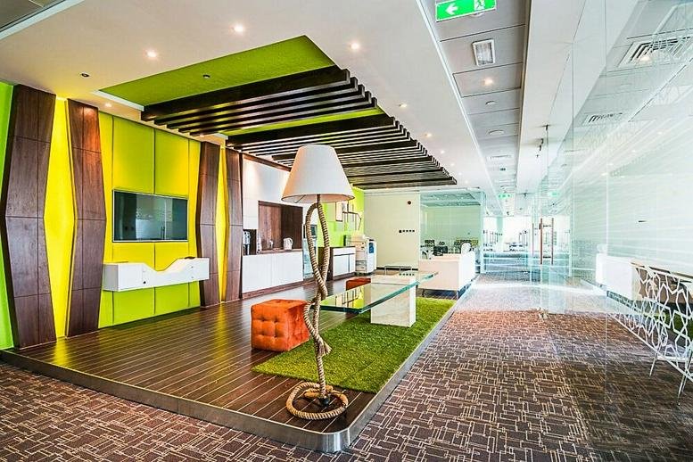 Modern lobby at Level 5, Düsseldorf Business Point with a wood-paneled feature wall and green accents.