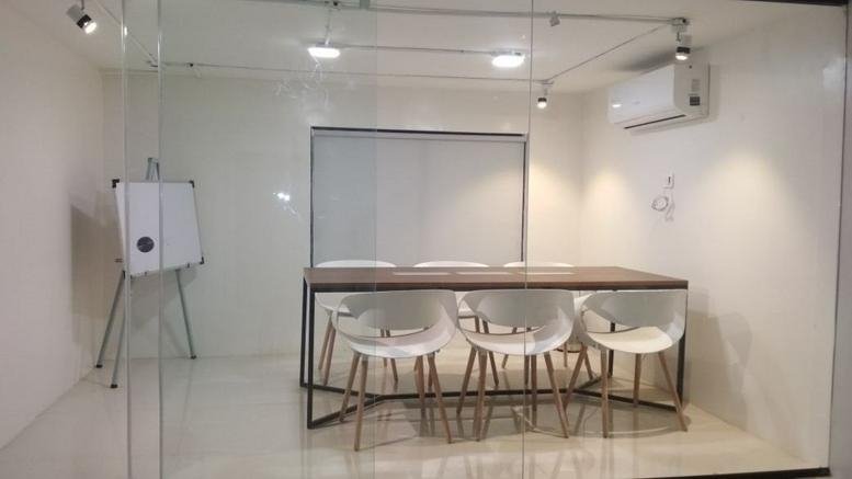 Bright glass-walled conference room at D27, Varsha Park, Near Bhairavee Restaurant.