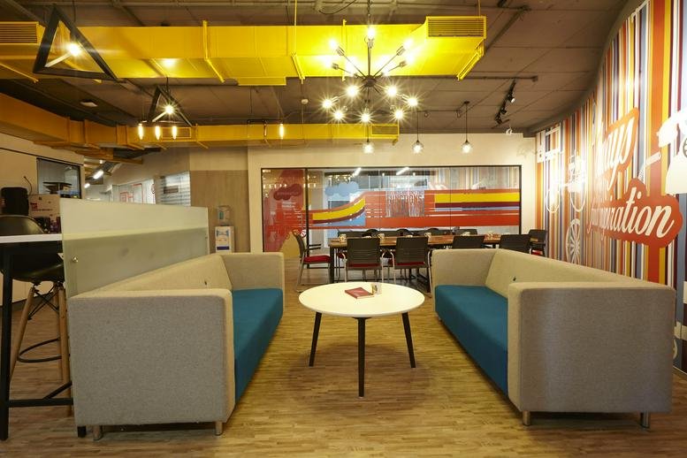 Spacious lounge at Dayananda Sagar University Hosur Main Road with modern sofas and industrial yellow ductwork.