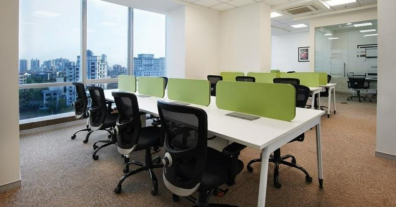 Spacious open-plan workspace at DBS House, 26 Cunningham Road, Bangalore with city views and lime green partitions.