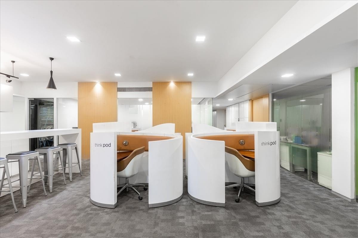 Modern coworking area at DNR 90 featuring semi-private curved workstations.
