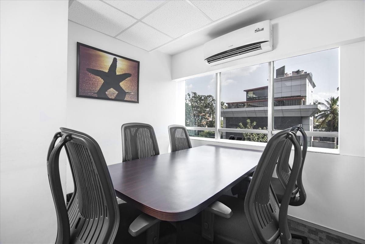 Meeting room at Duru House with dark wood table and view of Juhu through large windows.