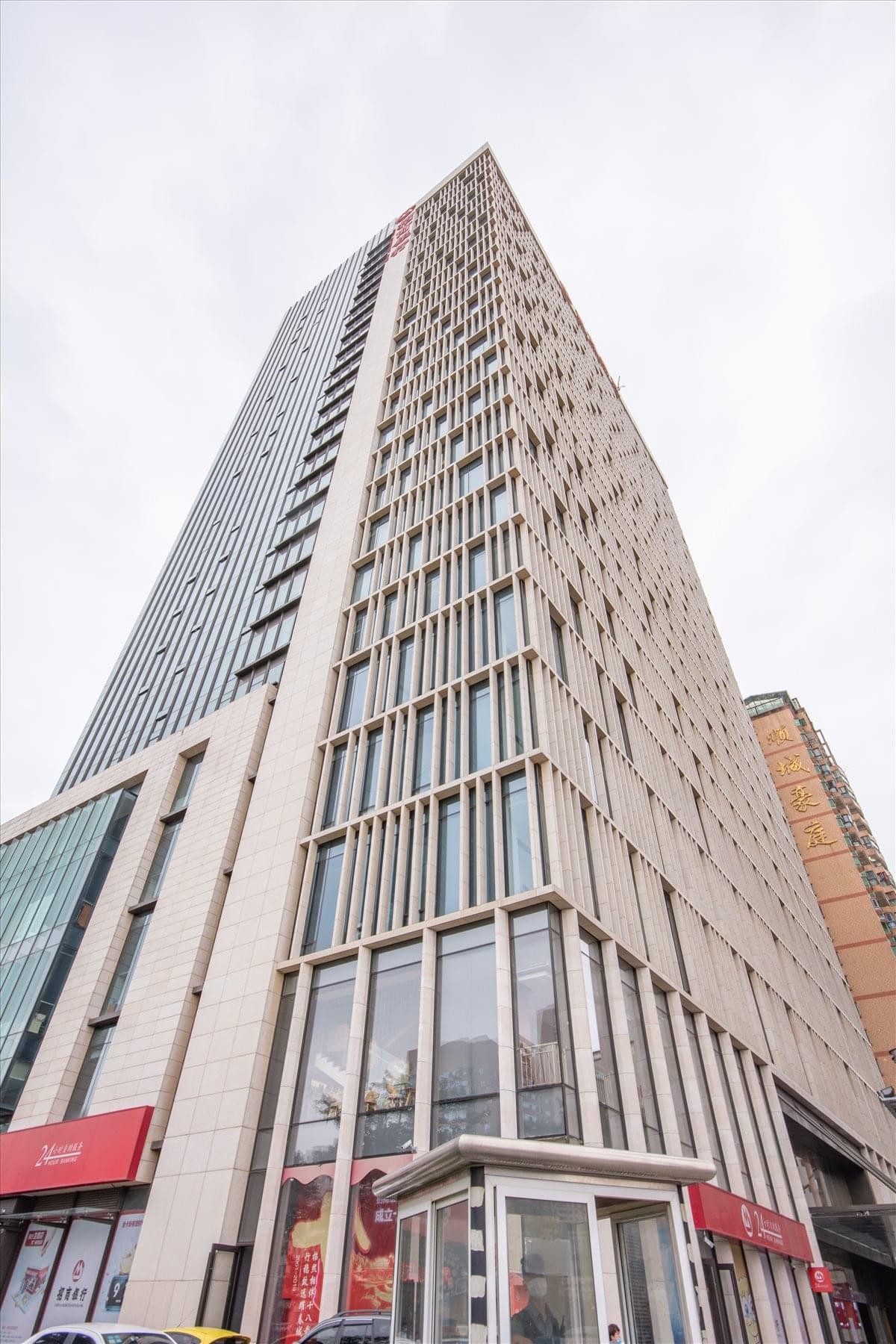 High-rise exterior view of the modern East Tower Dongfangshouzuo building against a bright sky.