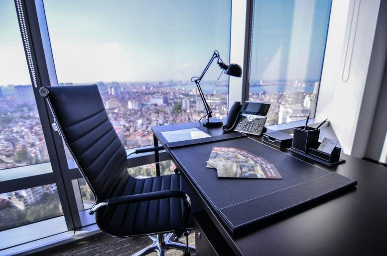 Private office with a leather chair and desk overlooking the city from the Hanoi Lotte Center.