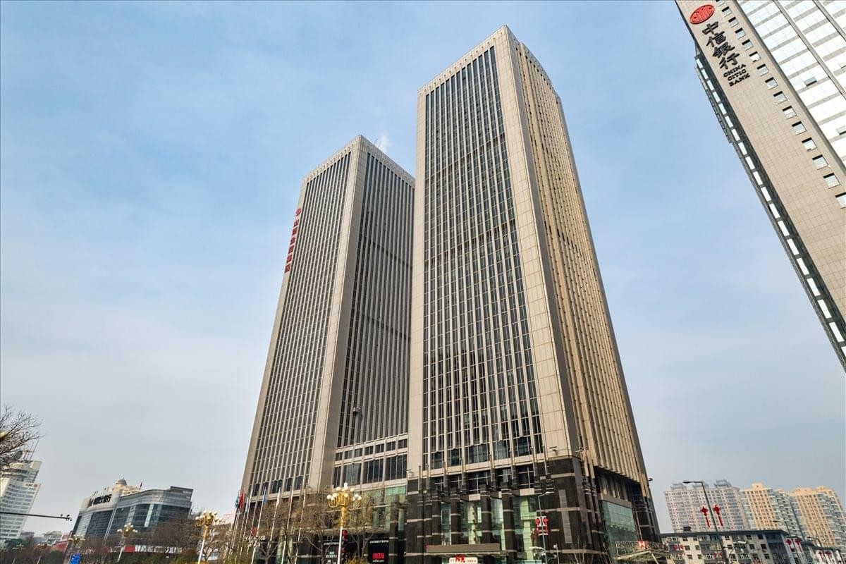 Exterior view of the twin skyscrapers of the East Tower, Shanxi World Trade Centre under a clear blue sky.