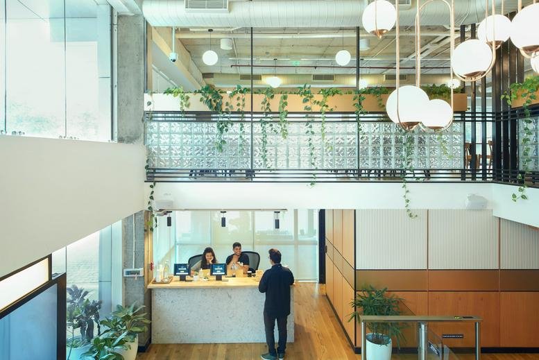 Spacious reception area at Embassy Golf Links, Cinnabar Hills with globe lights and a wooden front desk.