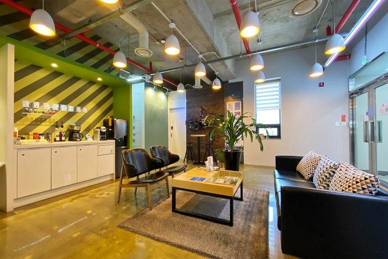 Spacious communal lounge at Nonhyun 237 Bldg. 3F / 4F with a coffee bar, striped feature wall, and modern seating.
