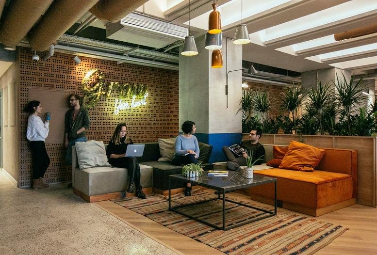 Spacious communal lounge at Esentepe, Harman Sokağı No:5 featuring brick walls and neon signage.