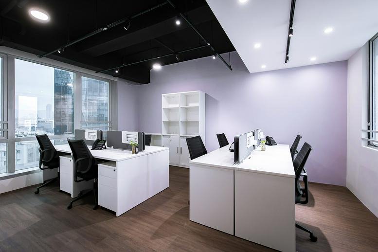 Spacious open-plan coworking area at Everglory Centre with modern white desks and city views.