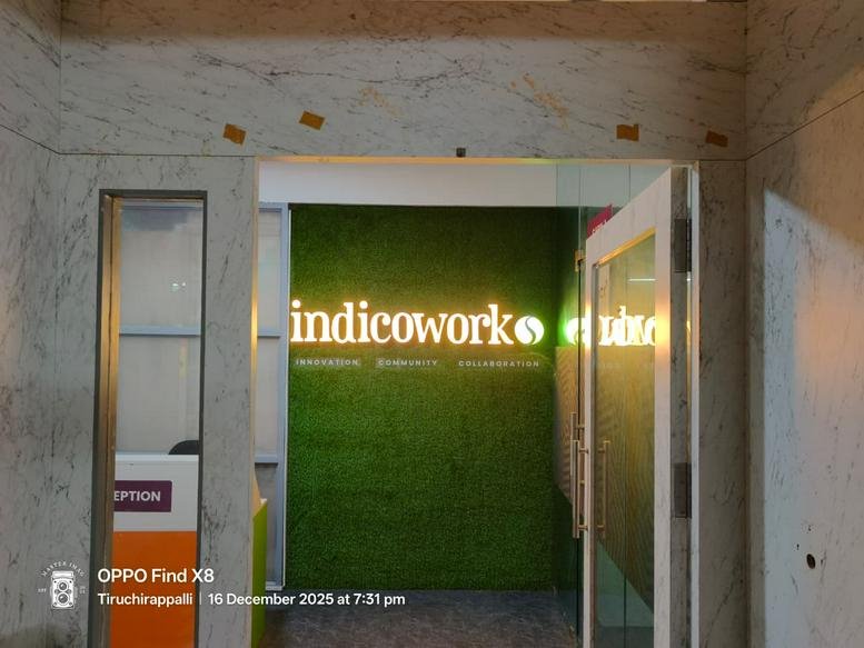 Brightly lit reception area at Fort Station Road, Tennur, Tiruchirappalli, India with a green moss feature wall.